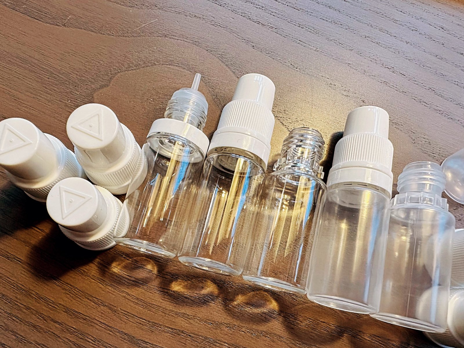 Puste szklane butelki na e-liquid z zakraplaczami i zakrętkami zabezpieczonymi przed dziećmi